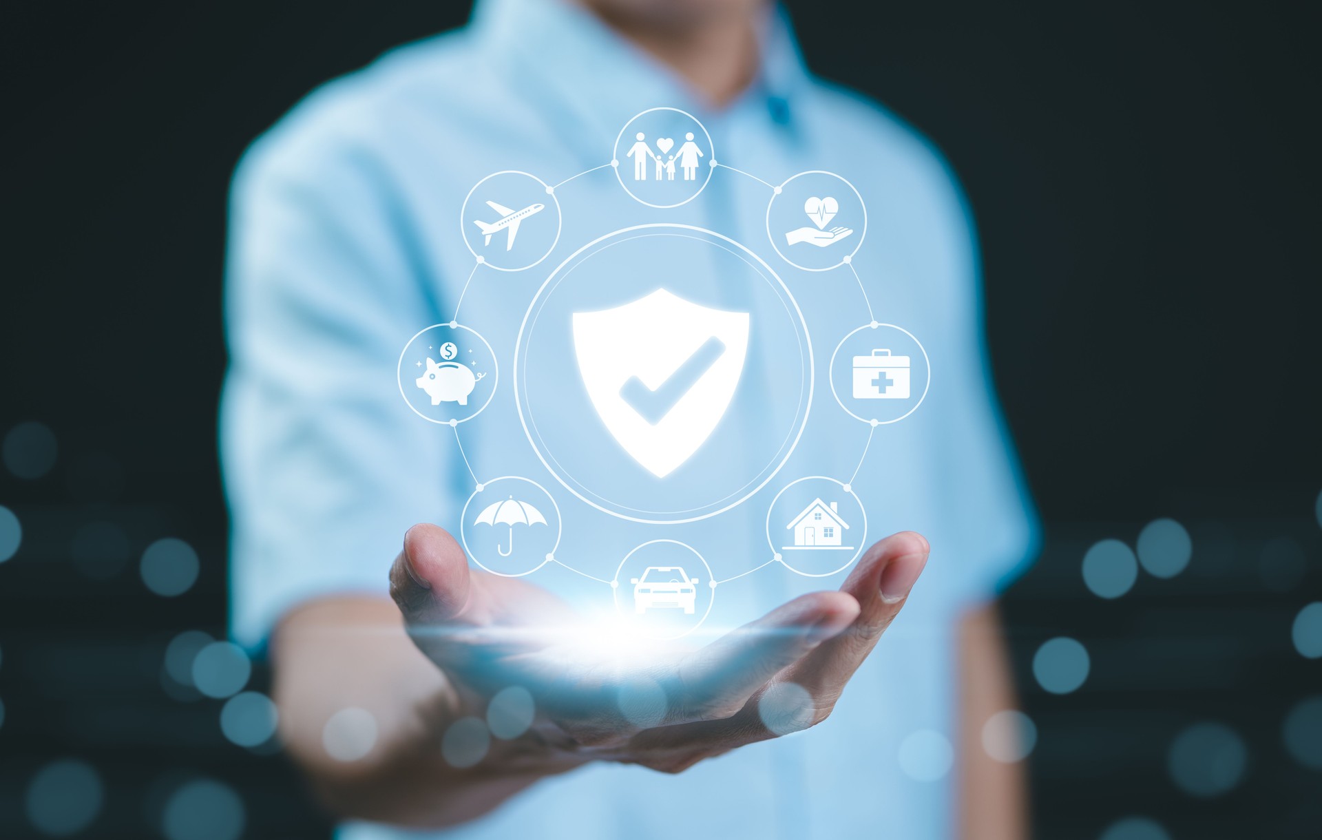 Comprehensive insurance coverage. protection concept. A person holds digital shield icon representing different types of insurance, including health, home, car, travel, life, protection, and security.